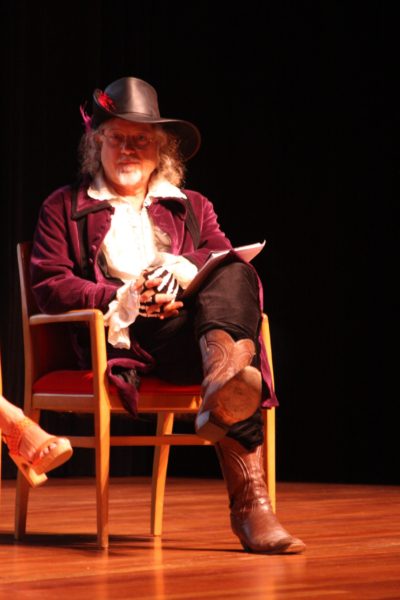 Whyville creator Dr. James M. Bower, in pirate costume, sits onstage in an armchair