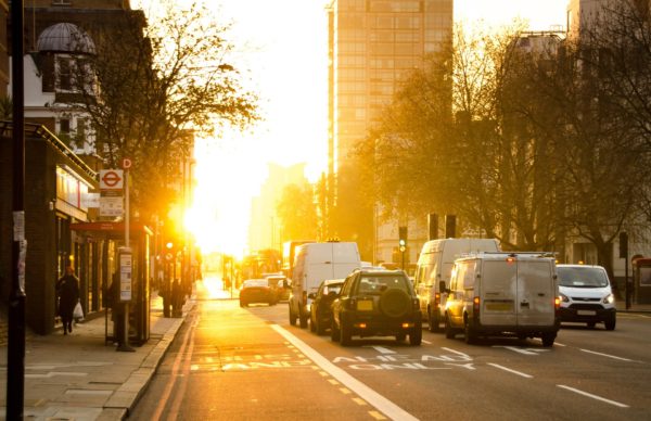 Sun rising over cars on a city street
