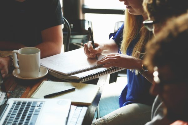 Blurred profiles of four coworkers around a meeting table