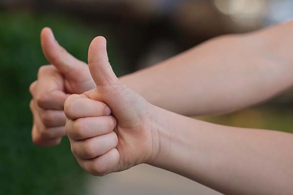 Two right hands making "thumbs-up" signs