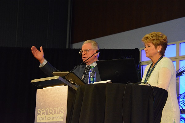 Ray Zine onstage for Sensory 2016 keynote, with his wife standing near the podium