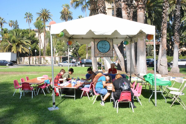 Participants drawing in an outdoor tent