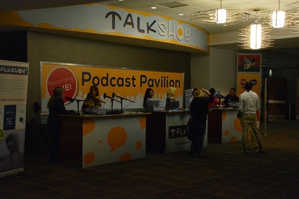 Podcast Pavilion setup with Jenna and Dot on mic and people around