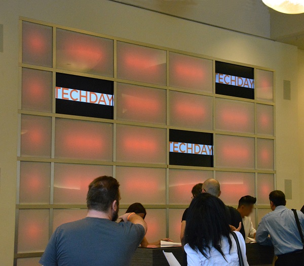 TechDay LA attendees sign in near an orange lighted wall with the word TECHDAY displayed