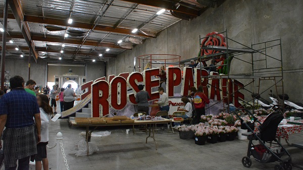 Staffers decorate "Rose Parade" sign at Phoenix Decorating Company facilty