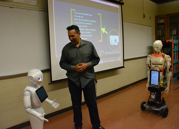 Walter Martinez of CSULB stands between the Pepper and Evo robots