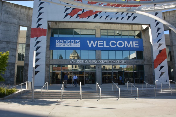 Attendee walks into San Jose McEnery Conference Center, which has a blue banner advertising Sensors Expo and Conference