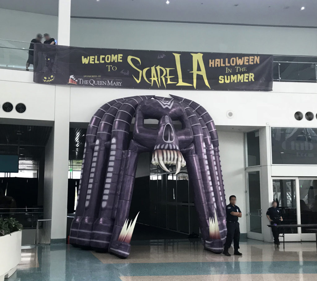 ScareLA 2018 entrance with banner and purple skull over the doorway as security staff stand guard