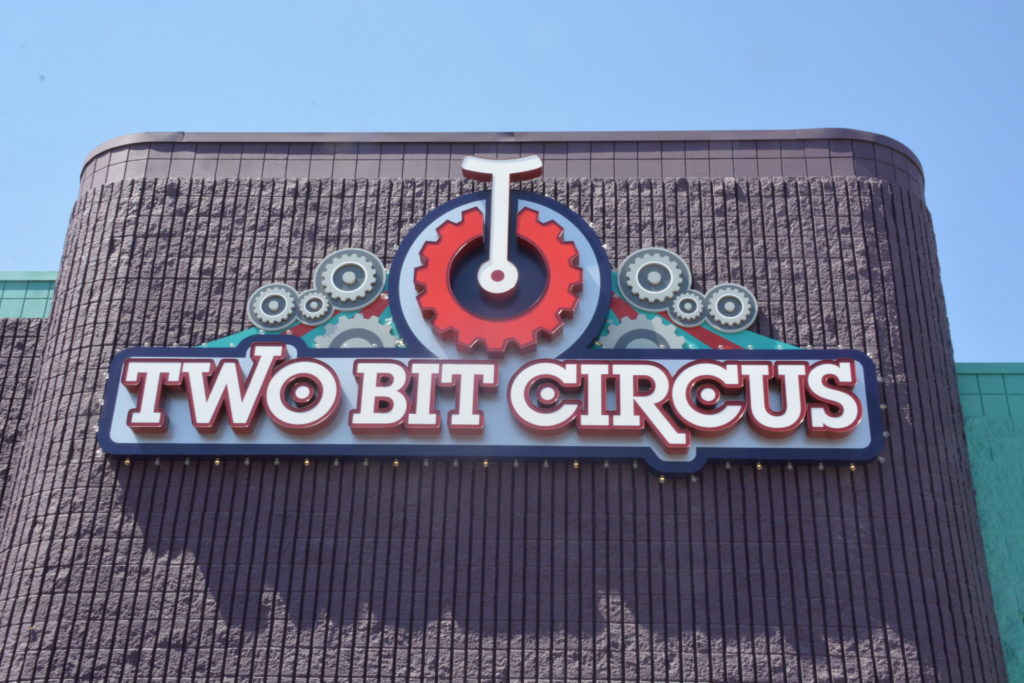 Two Bit Circus sign and unicycle logo on facade of Micro Amusement Park™ building