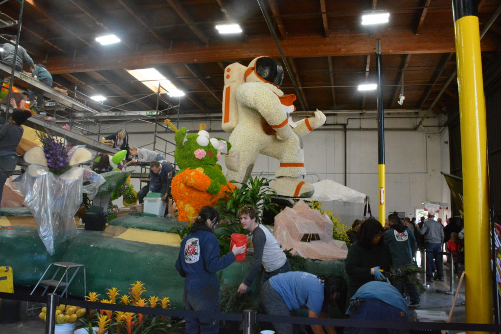 Cal Poly float with astronaut and students around it at Phoenix Rosemont float barn
