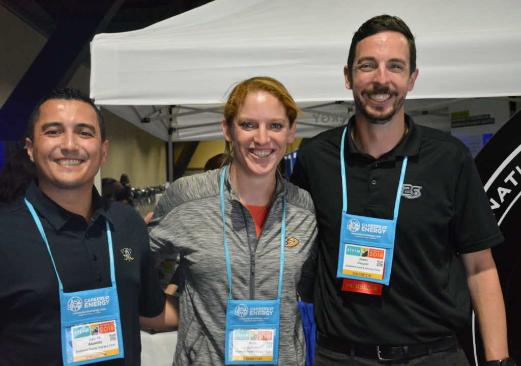 S.C.O.R.E. team smiles from the booth on the California STEAM Symposium exhibit floor in Octover, 2018