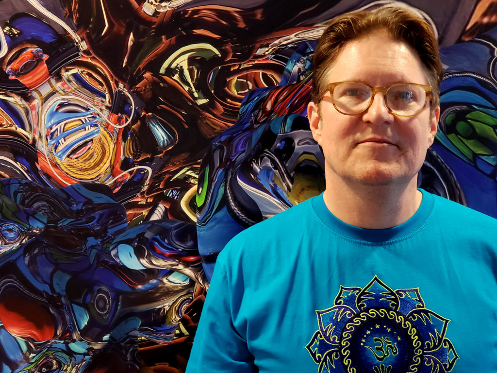 Artist Kevin Mack stands before one of his his psychedlindscapes" for virtual reality