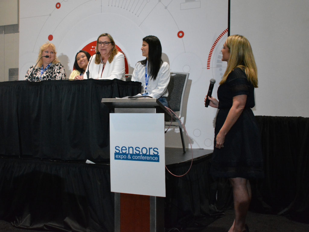 WISE panel of four women engineers interact with moderator near a lectern with "Sensors Expo and Conference" banner