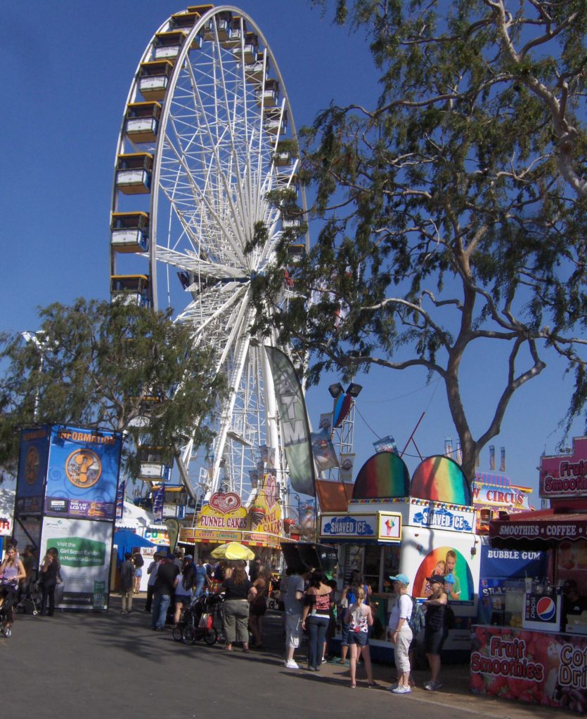 Orange County Fair midway with Ferris wheel and fairgoers near concessions, 2013