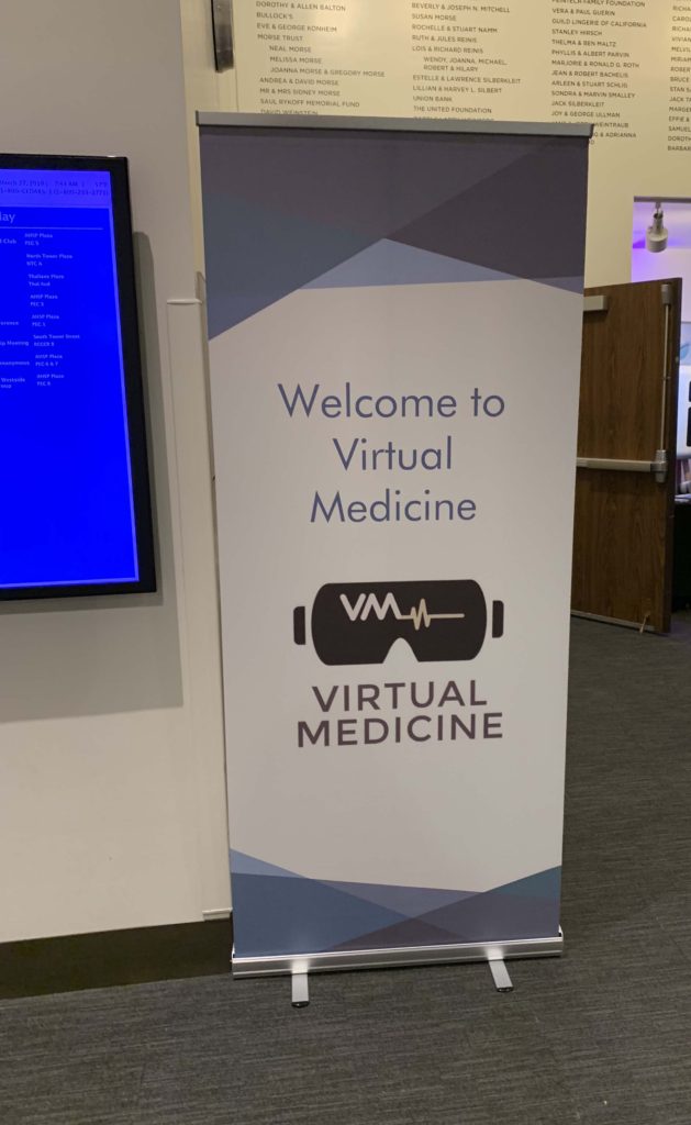 White "Welcome to Virtual Medicine" standup sign outside open door