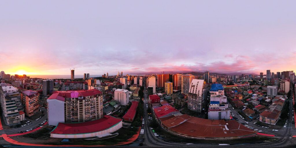 Virtual-reality representation of a city landscape with purple sky and a sunrise