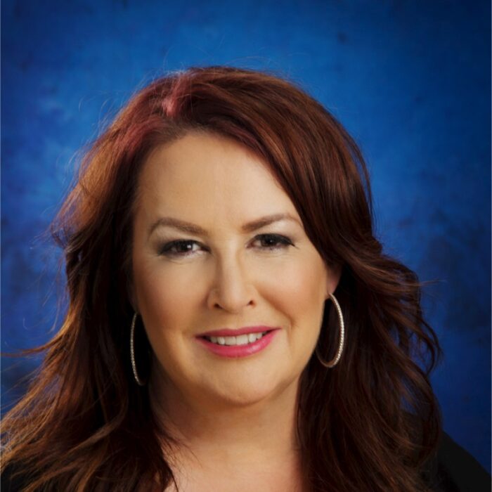 LMG PR Founder/President Donna Loughlin smiles against a dark-blue background