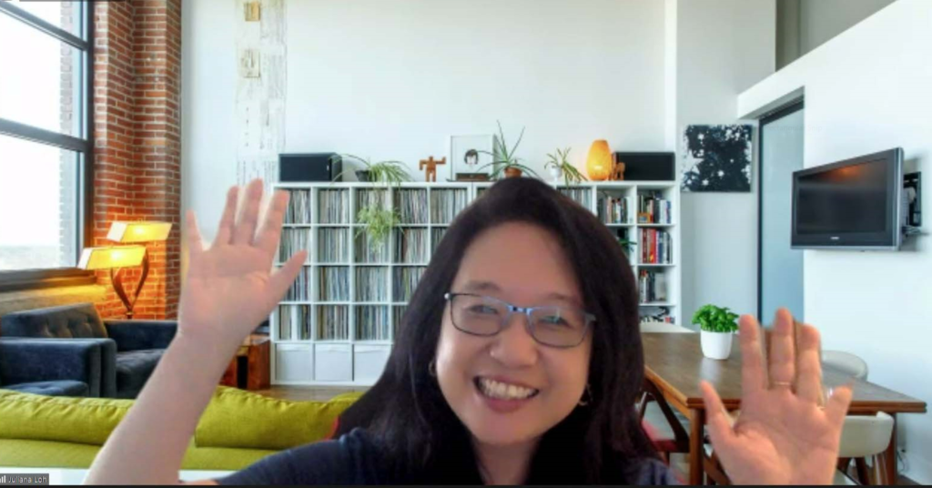 "Awaken the Giants" creator, artist Juliana Loh, smiles and waves from her home office on a Zoom screen