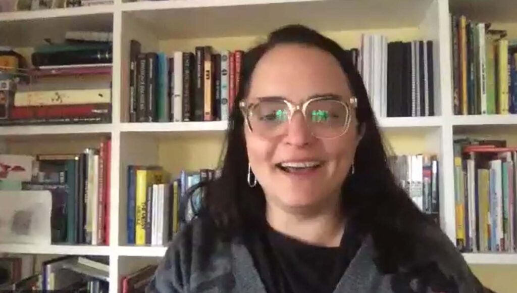 Matavrsed: See Beyond the Hype co-author Samantha G. Wolfe smiles against a background of bookshelves while discussing the metaverse and its impact on future daily life.