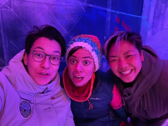 Found in the Fjords creators Aya Walraven, Dr. Louise Edwards and Tiffany Duong laugh and clown in a pink-lit room setting.