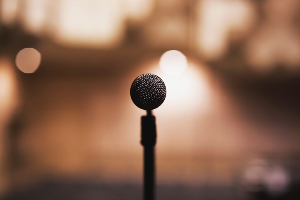 Standing microphone against a gold spotlight