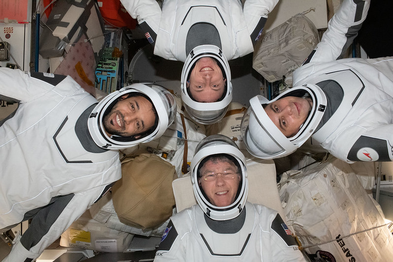 Expedition 69 crew mates pose in SpaceX pressure suits