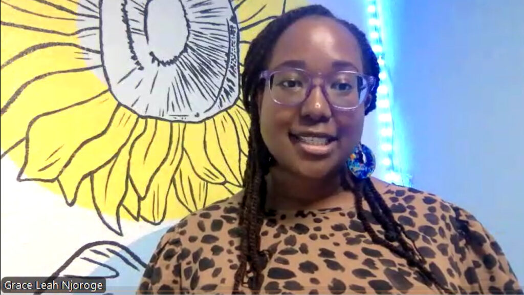 LVNHM Director of Education Grace Njoroge smiles in front of a giant sunflower mural background while discussing "Wild World"