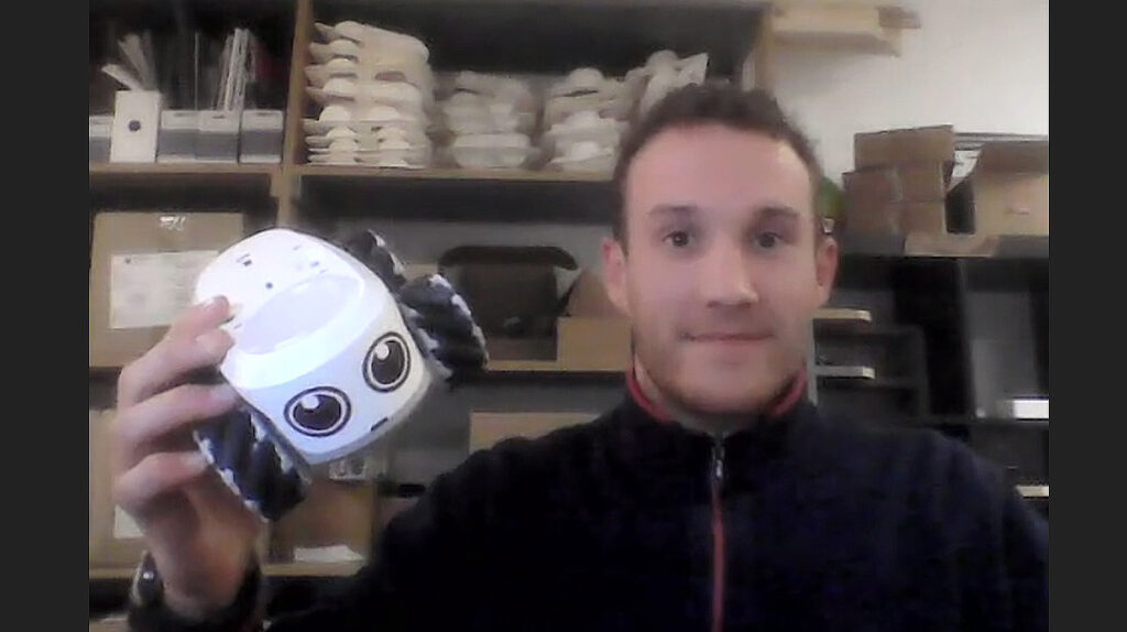 ILO Founder Simon Le Berre displays his educational robot before a Zoom background