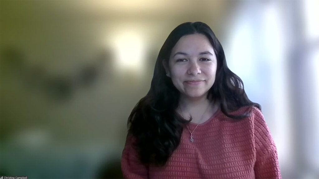 Think Tank Science Program Manager Christina Campbell smiles against a blurred Zoom background.