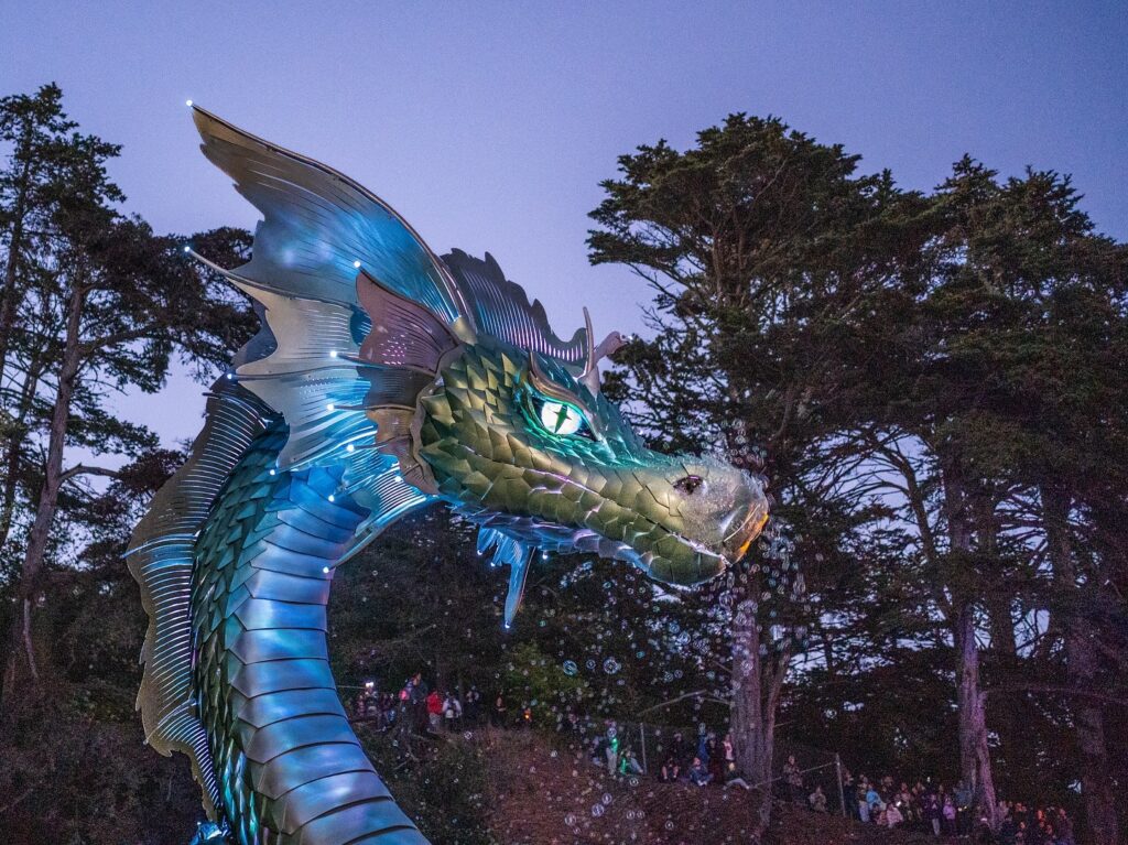 Closeup of Naga's face, at night, with purple and blue lighted scales and a yellow-green, lighted eye.