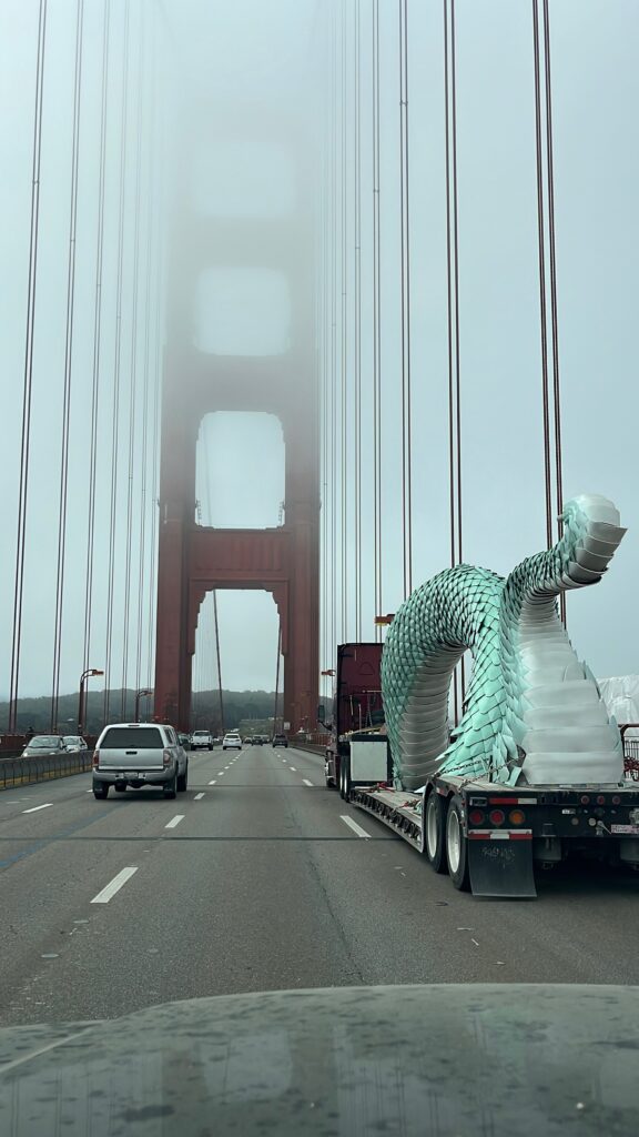 Naga tail section and middle hump traveling on a flatbed truck on the Golden Gate Bridge.