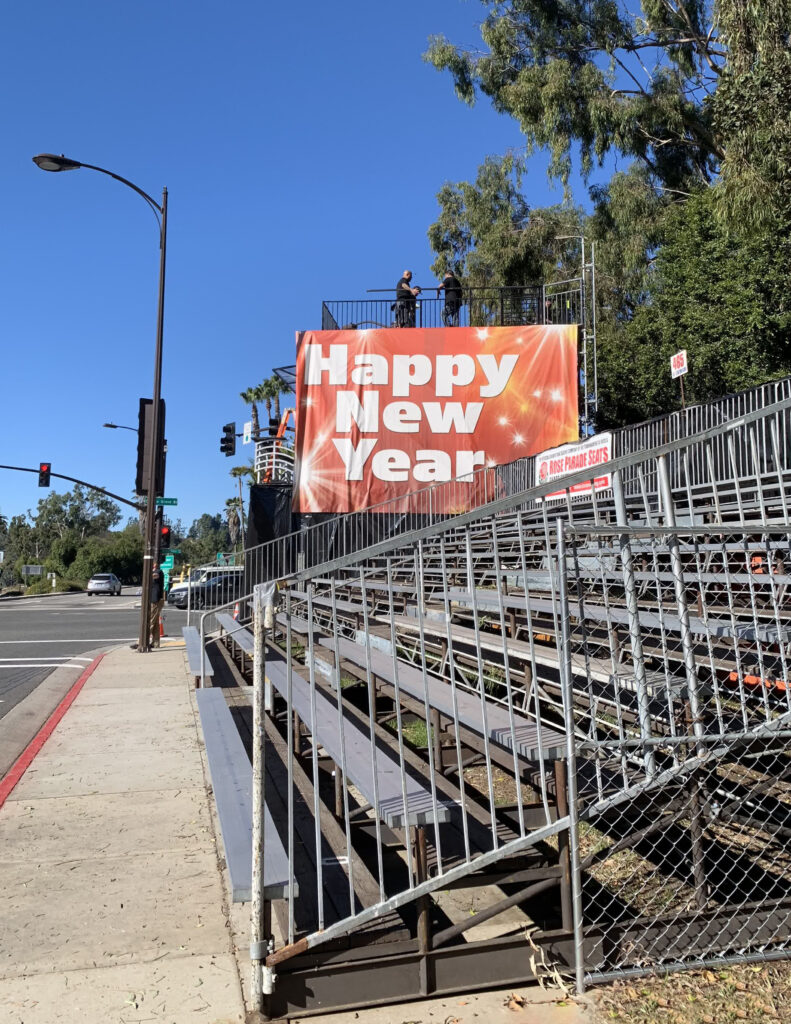 Banner reads "Happy New Year" near empty grandstand prior to Rose Parade