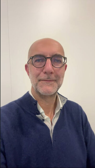 Abeye Co-Founder and CEO Michael Kodochian, inventor of Lexilens, smiles against a cream-colored background.