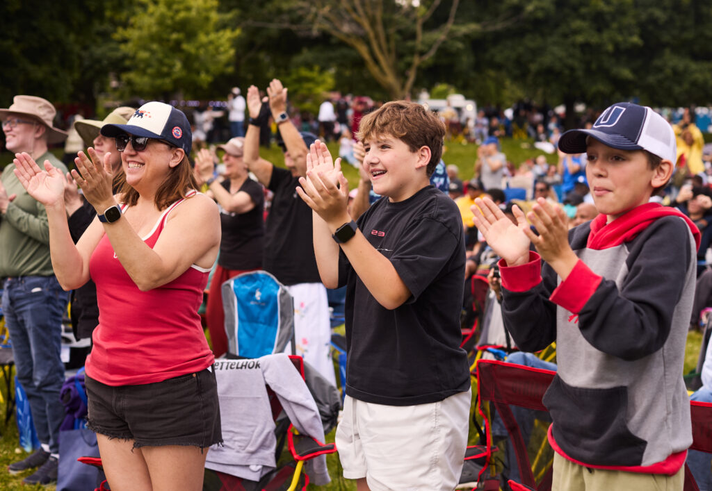 Audience applauds on the lawn of the Obama Presidential Center