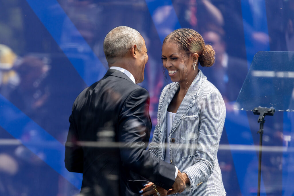 President and Mrs. Obama embrace and smile following her remarks at the Grand Opening of the Obama Presidential Center.
