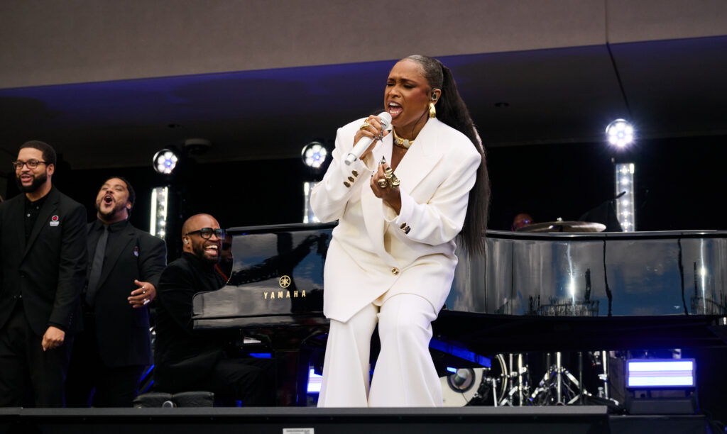 Jennifer Hudson, in a white pants suit, performs The National Anthem and The Impossible Dream during the Grand Opening Dedication Ceremony at The Obama Presidential Center The National Anthem and The Impossible Dream during the Grand Opening Dedication Ceremony at The Obama Presidential Center .