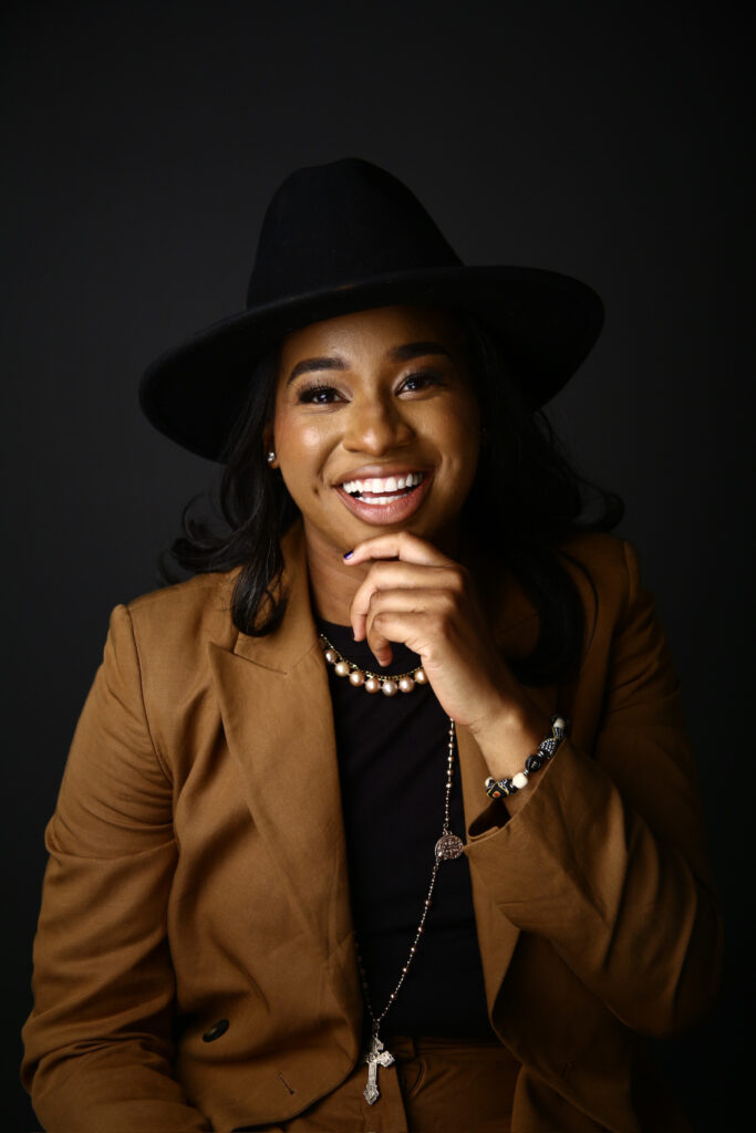 Stemuli Founder and CEO Taylor Shead, in a brown jacket, black hat and black sweater with a silver necklace.
